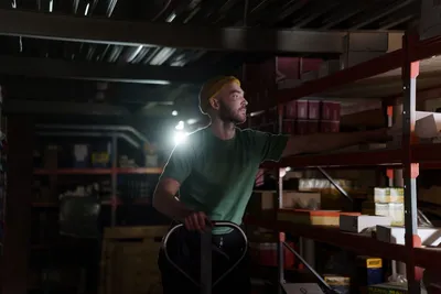 A dedicated worker organizing inventory on warehouse shelves with focused concentration.